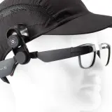 Ein schwarzer Hut mit einer Kamera, die per Vision gesteuert wird, ist an einer Brille befestigt.
