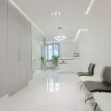 Nowoczesne wnętrze poczekalni kliniki dermatologii estetycznej z recepcją i wygodnymi fotelami.
