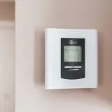 Termostato Stelpro en pared. Muestra 22.5°C y 18.0°C. La diferencia entre termostato y cronotermostato es la programación horaria.
