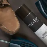 Skórzany but i niebieskie prawidła obok puszki cocciné antiacqua impregnat do skór i tekstyliów.