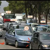 A chaotic traffic jam in Sicily, with cars in multiple lanes. A driver in a blue car has a speech bubble saying "YES I CAN!".