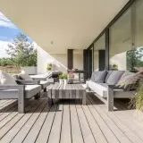 Moderne Lounge-Möbel auf Holzterrasse laden zum Entspannen ein. Perfekt, um die Terrasse gestalten und den Sommer zu genießen.