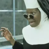 Whoopi Goldberg w roli siostry w filmie "Zakonnica w przebraniu 2: Powrót do habitu" z okularami i w rozbawionej pozie.