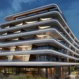 Nowoczesny hotel 5 gwiazdkowy z falującymi tarasami i subtelnym oświetleniem, otoczony zielenią.