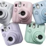 Pięć aparatów Instax Mini 13 w pastelowych kolorach: białym, różowym, niebieskim, fioletowym i miętowym.