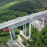 Most autostradowy w budowie, wsparty na filarach z betonu C30/37, otoczony lasem.