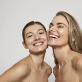 Dos mujeres sonríen, sus rostros radiantes y piel luminosa, un reflejo de la confianza que brinda Oslo Skin Lab.