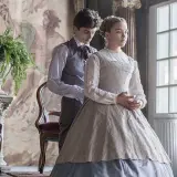 Małe kobietki obsada: Timothée Chalamet i Florence Pugh w strojach z epoki, w eleganckim wnętrzu.