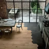 Un'elegante cucina con pavimenti che uniscono il calore del **parquet** e il design moderno delle **maioliche** esagonali scure.