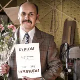 Adam Woronowicz w roli Huberta Myślińskiego z dyplomem i kwiatami. Scena z jednego z jego filmów.