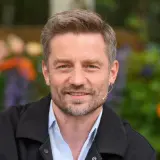 Marcin Rogacewicz, znany z ról w serialach, prezentuje się z uśmiechem. Jego wiek dodaje mu uroku.