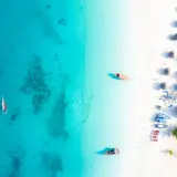 Rajska plaża na Zanzibarze, gdzie turkusowa woda i biały piasek tworzą idealne tło dla tradycyjnych łodzi. Można tu poczuć atmosferę wakacji, marząc o przygodach i wymieniając się wrażeniami, jakby to była lokalna waluta.