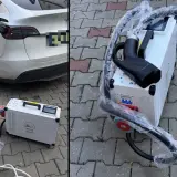 Domowa stacja ładowania samochodów elektrycznych cena. Biała Tesla podłączona do ładowarki na kostce brukowej.