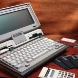 Stary komputer IBM PC Convertible, dyskietki i kalkulator. Kto wymyślił system binarny? To pytanie zadajemy, patrząc na te relikty przeszłości.