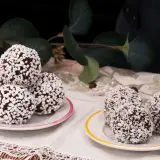 Två fat med chokladbollar, några rullade i kokosflingor och andra i små vita strösselkulor. En härlig syn av kokos bollar!