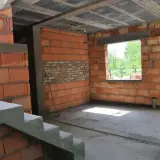 Budynek gospodarczy w trakcie budowy, z ceglanymi ścianami i betonowymi schodami. Czy w takim miejscu można mieszkać?