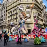 Gigantescas figuras de fantasía, como un dragón rosa y una mujer con un pegaso, dominan la calle en las Fallas 2026.