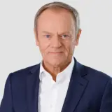 Donald Tusk w granatowej marynarce i białej koszuli. Chcesz znać numer do Tuska?