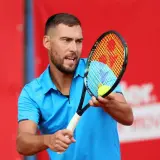 Jerzy Janowicz, z rakietą i piłką, może symbolizować koniec kariery.