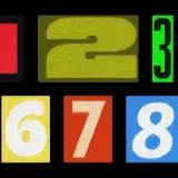 Numeri da 0 a 9 su sfondo nero. Il 9 è giallo su verde scuro. Come si dice 99 in inglese? Ninety-nine.