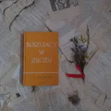 Buszujący w zbożu J.D. Salingera, opowieść o dojrzewaniu i poszukiwaniu autentyczności, leży na pożółkłych kartkach.