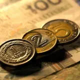 Monety 1, 2 i 5 złotych na tle banknotu 100 zł. Zastanawiasz się, przedterminowy wykup obligacji ile trwa?
