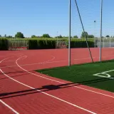 Bieruński ośrodek sportu i rekreacji: bieżnia, boisko ze sztuczną trawą, bramki i zadaszone ławki.