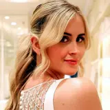 Valentina Ferragni sonríe con un vestido blanco de tirantes y detalles de perlas, en una tienda de novias.