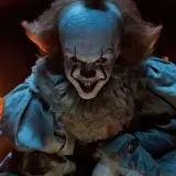 Gripsou le clown dansant, au sourire terrifiant, se tient dans une église sombre, ses yeux brillants fixant l'objectif.
