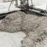 Świeży beton wylewany z betoniarki. Z czego jest cement? Z wapienia i gliny, które po wypaleniu i zmieleniu tworzą spoiwo.