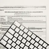 Formularz PCC-3 i klawiatura. Wpisz "podatek od nieruchomości" w tytule przelewu, aby poprawnie opłacić należność.