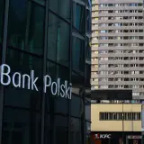 Logo PKO Bank Polski na szklanej fasadzie. W tle blok mieszkalny i KFC. PKO BP rekomendacje.