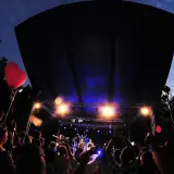 Koncert w amfiteatrze w Kołobrzegu. Tłum bawi się pod sceną, widać czerwone serce na balonie.