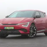 Czerwone Kia EV6 GT na mokrej drodze, w tle mgła.