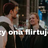 Uśmiechnięta kobieta patrzy na mężczyznę, a jej spojrzenie i postawa sugerują, że jej się podoba. Czy ona flirtuje?