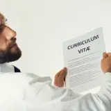 Mężczyzna z brodą analizuje CV, szukając kluczowych kompetencji przyszłości.