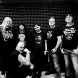 Sześciu mężczyzn w czarnych koszulkach z zespołami, w tym z King Diamond. Widać, że mają w sobie mnóstwo **wena** do tworzenia muzyki.