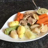 Tête de veau savoureuse servie avec des légumes racines et une sauce crémeuse.