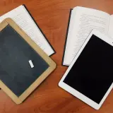 Tablica, książka i tablet na drewnianym stole. Czy postać literacka może istnieć bez konfliktu wewnętrznego?