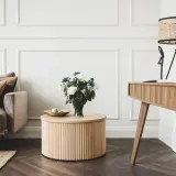Elegancki salon w stylu klasycznym: beżowa sofa, drewniany stolik z bukietem róż, biurko i lampa z wiklinowym kloszem.