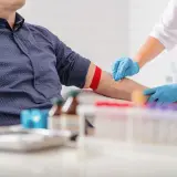 Pielęgniarka pobiera krew od pacjenta, co może pomóc w diagnostyce, co wypłukuje żelazo z organizmu.