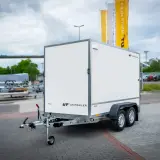 Biała przyczepa towarowa z logo UNITRAILER. Dowiedz się, jak zarejestrować przyczepę rolniczą samoróbkę.