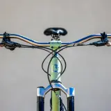Close-up of a bicycle's handlebars and front fork, featuring Hayes Dominion A4 brakes, ready for a review.
