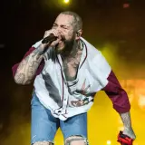 Post Malone Polska na koncercie, śpiewa z pasją w koszulce z Królikiem Bugsem i dżinsowych szortach.