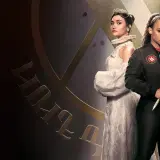 Dwie młode kobiety, jedna w koronkowej sukni i koronie, druga w kurtce z naszywką, stoją na tle stylizowanego logo. Zapowiedź serialu "Akademia wampirów".