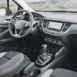 Interior del Opel Crossland X con asientos grises y negros, volante multifunción y pantalla táctil.