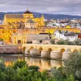 Puente Romano y Mezquita-Catedral de Córdoba, un ave que vuela sobre la historia, evocando un viaje desde Barcelona.