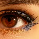 Ojos marrones con un espectacular maquillaje dorado y azul brillante.