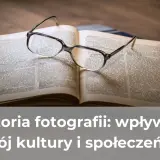 Okulary spoczywają na otwartej księdze, symbolizując zgłębianie historii fotografii i jej wpływu na kulturę.