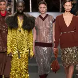 Modelos desfilan con atuendos brillantes. Un vestido amarillo con paillette y un traje marrón con lentejuelas destacan.